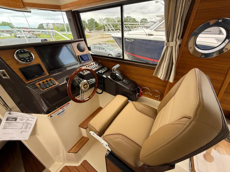 Slide: The Image of Helm of 2025 Ranger Tugs R-25 with modern controls and comfortable seating. - 16