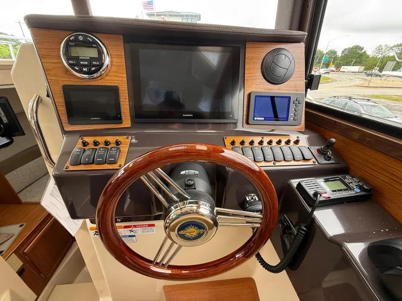 Slide: The Image of Helm of 2025 Ranger Tugs R-25 with modern navigation equipment and wooden steering wheel. - 17