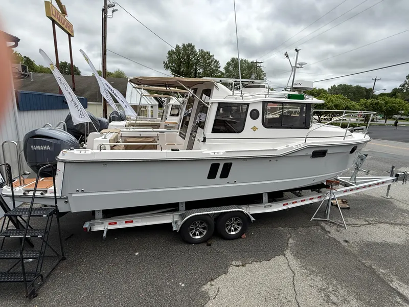 Slide: The Image of 2025 Ranger Tugs R-25 boat on trailer, parked outdoors, with Yamaha engine. - 2