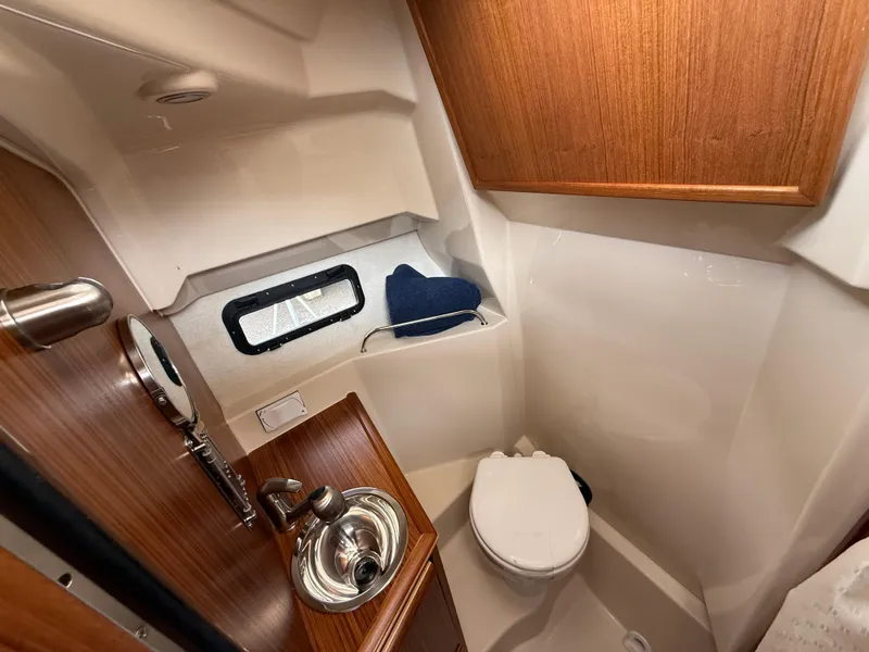Slide: The Image of 2025 Ranger Tugs R-25 boat bathroom with wood accents and compact design. - 20