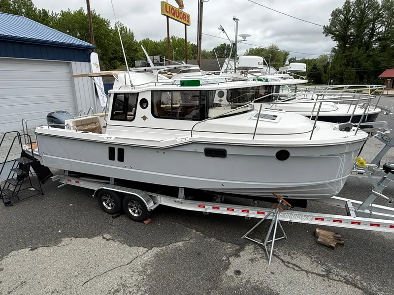 Slide: The Image of 2025 Ranger Tugs R-25 boat on trailer, parked outdoors near a building. - 3