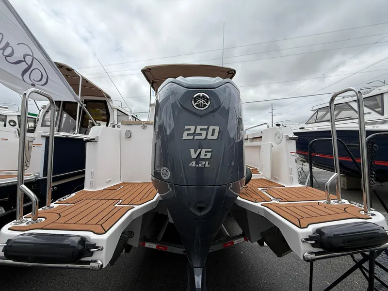 Slide: The Image of 2025 Ranger Tugs R-25 boat with Yamaha 250 V6 engine, docked under cloudy skies. - 4