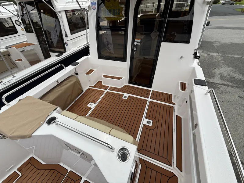 Slide: The Image of 2025 Ranger Tugs R-25 boat deck with teak flooring and seating area. - 5
