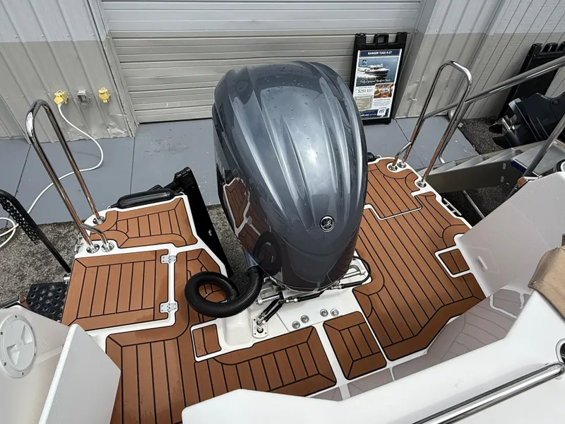 Slide: The Image of 2025 Ranger Tugs R-25 boat with outboard motor and teak-style deck flooring. - 6