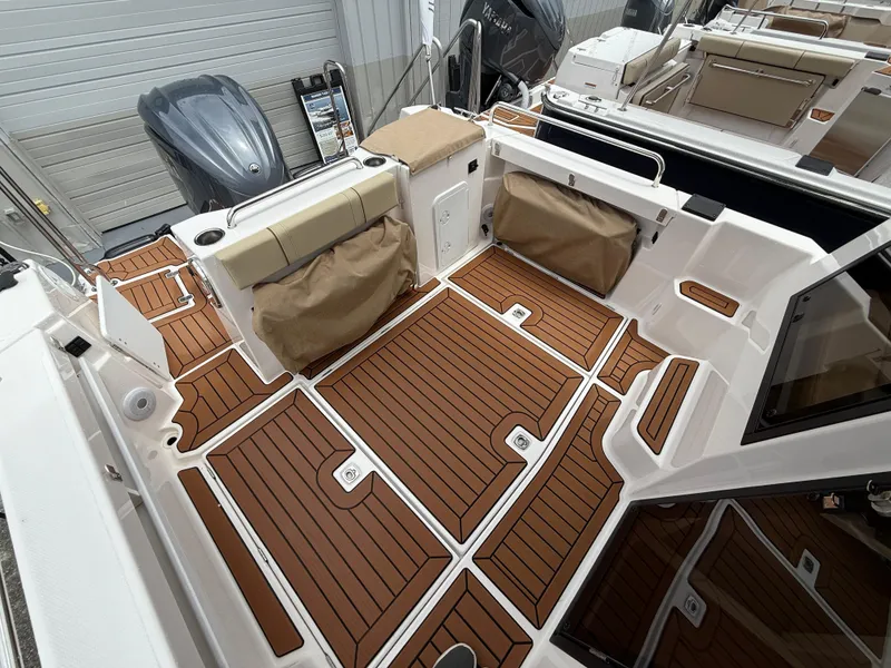 Slide: The Image of 2025 Ranger Tugs R-25 boat deck with wood finish and storage compartments. - 7