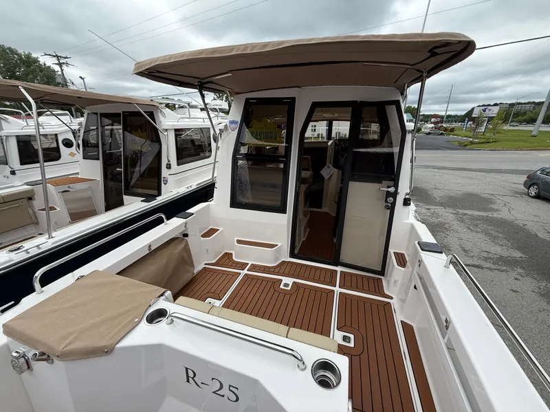 Slide: The Image of 2025 Ranger Tugs R-25 boat with spacious deck and canopy, docked outdoors. - 9