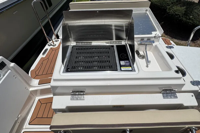 Slide: The Image of Outdoor kitchen on 2025 Ranger Tugs R-27 boat with grill and sink. - 4