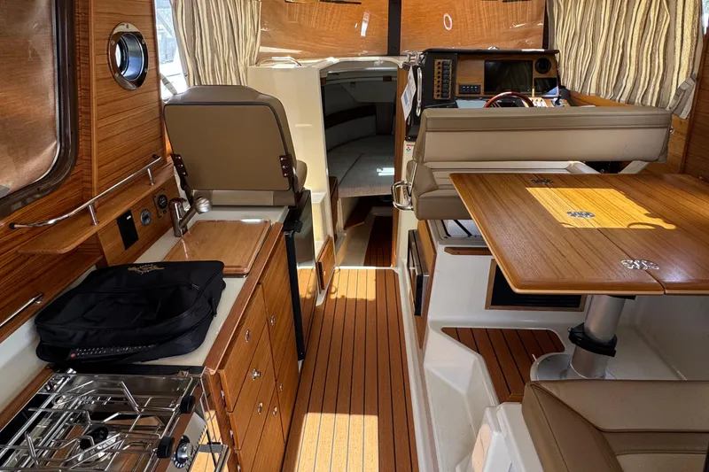 Slide: The Image of Interior of 2025 Ranger Tugs R-27 boat, featuring wood finishes and modern amenities. - 5