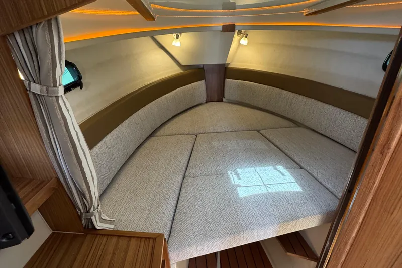 Slide: The Image of 2025 Ranger Tugs R-27 interior cabin with cozy bed and ambient lighting. - 8