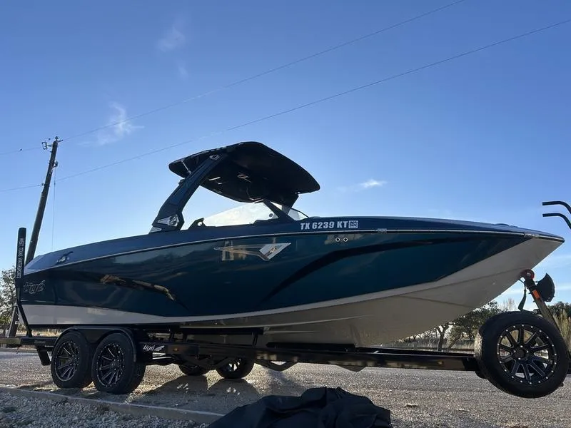 Slide: The Image of 2023 Tigé Z5 boat on trailer under clear blue sky. - 3
