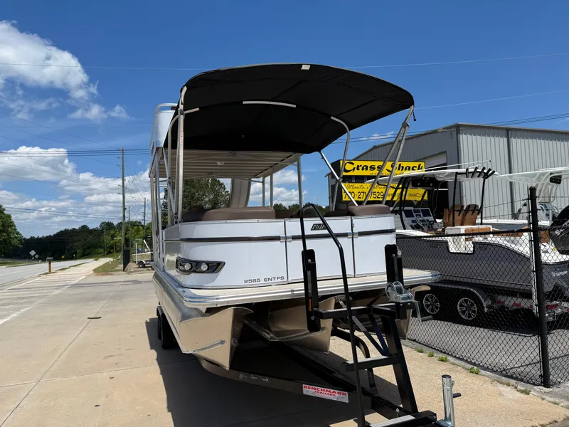 Slide: The Image of 2025 Avalon Catalina Entertainer Funship boat on trailer, parked outdoors under blue sky. - 2