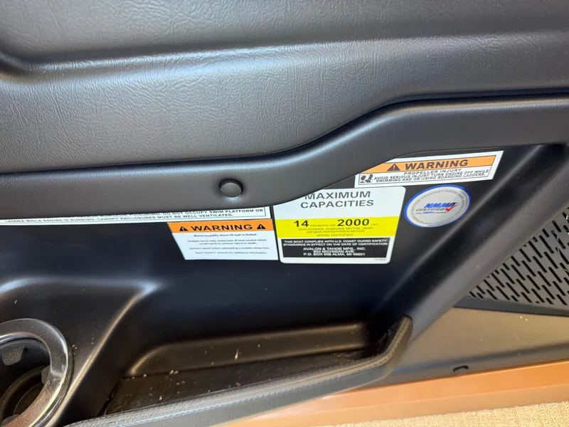 Slide: The Image of 2025 Avalon Catalina Entertainer Funship interior with warning labels and cup holder. - 35