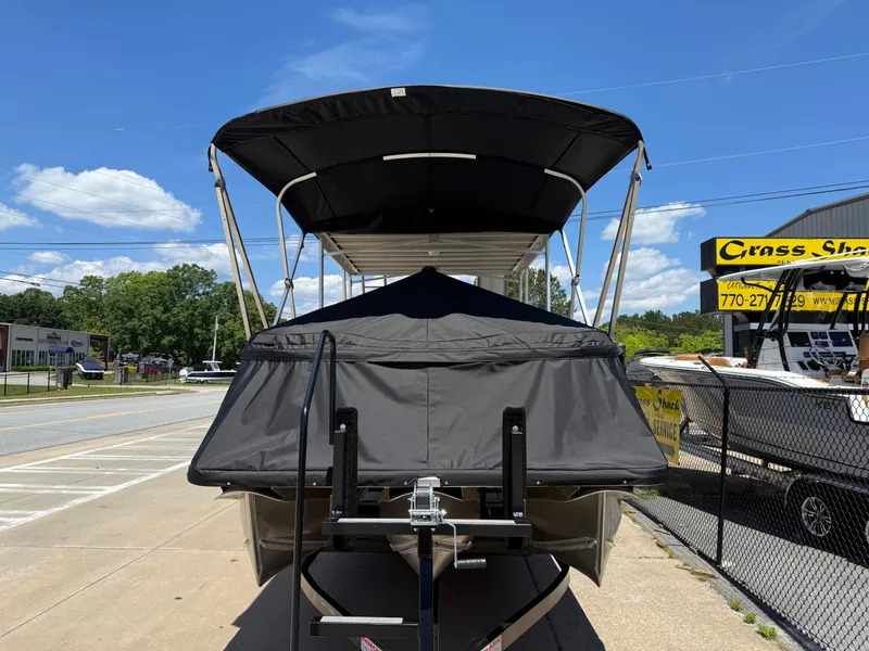 Slide: The Image of 2025 Avalon Catalina Entertainer Funship boat on trailer, covered, sunny day. - 6
