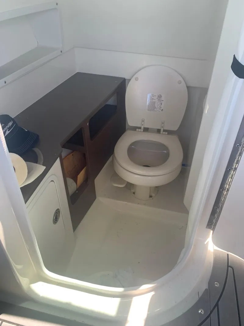 Slide: The Image of 2021 Sea Ray SDX 270 Outboard boat interior with toilet and storage area. - 4