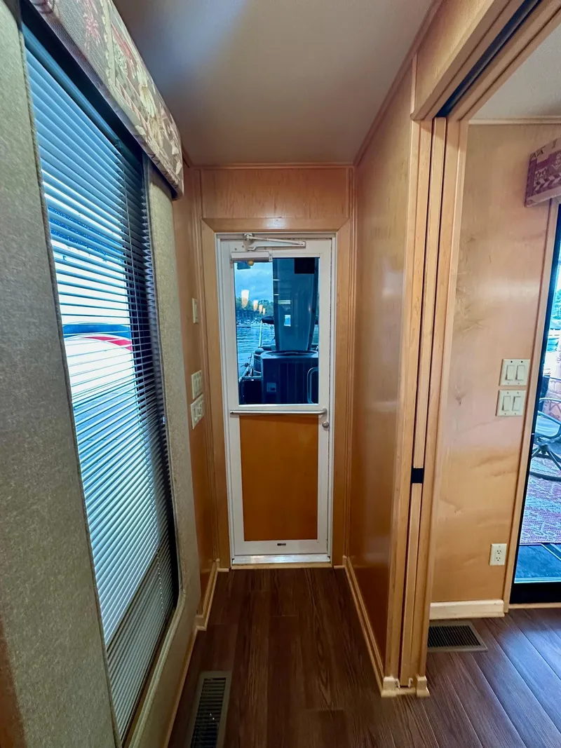 Slide: The Image of Narrow hallway in 2006 Stardust Cruisers 16x78 houseboat with wooden flooring and door. - 12
