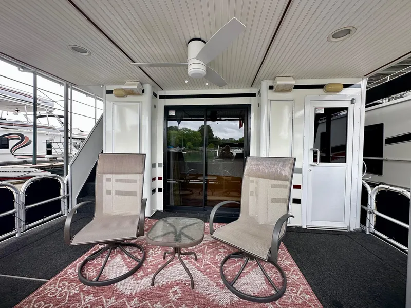 Slide: The Image of 2006 Stardust Cruisers 16x78 houseboat deck with chairs, table, and ceiling fan. - 13