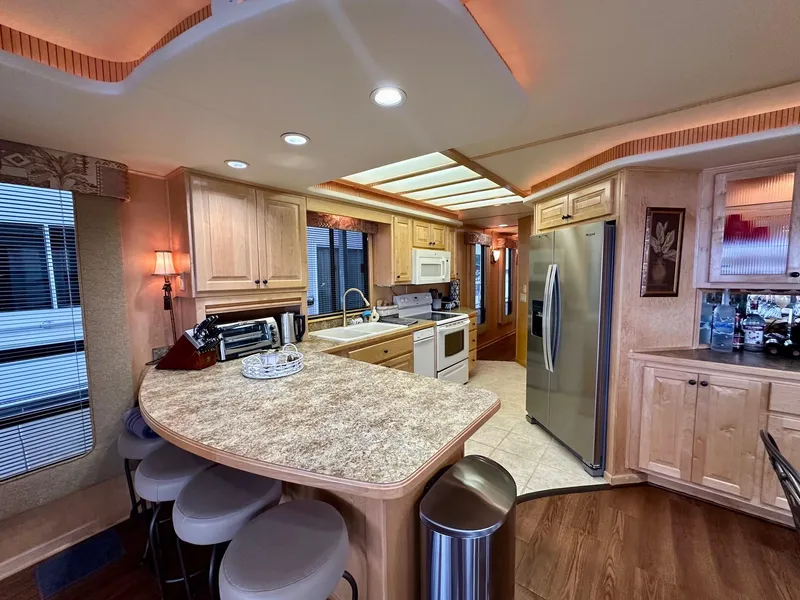 Slide: The Image of Luxurious 2006 Stardust Cruisers 16x78 houseboat kitchen with modern appliances and elegant wood cabinetry. - 4