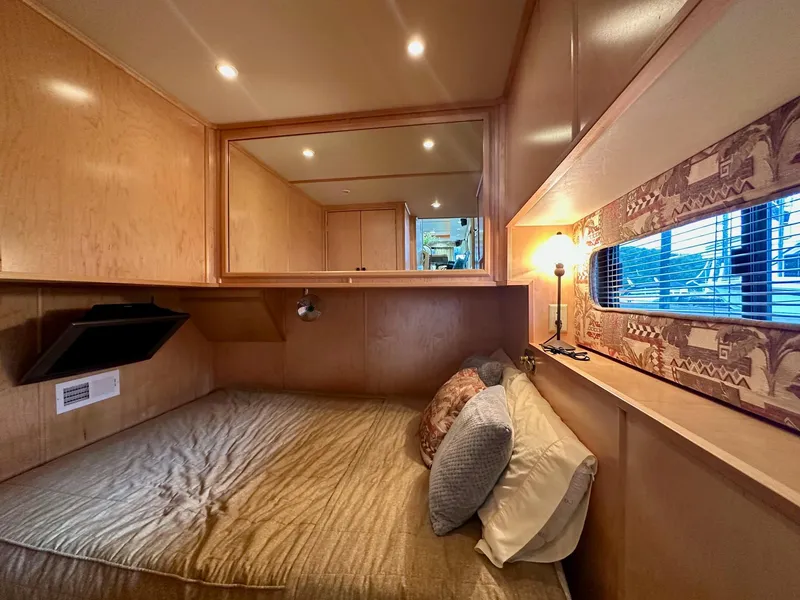 Slide: The Image of Cozy bedroom in 2006 Stardust Cruisers 16x78 houseboat with wood paneling and soft lighting. - 7