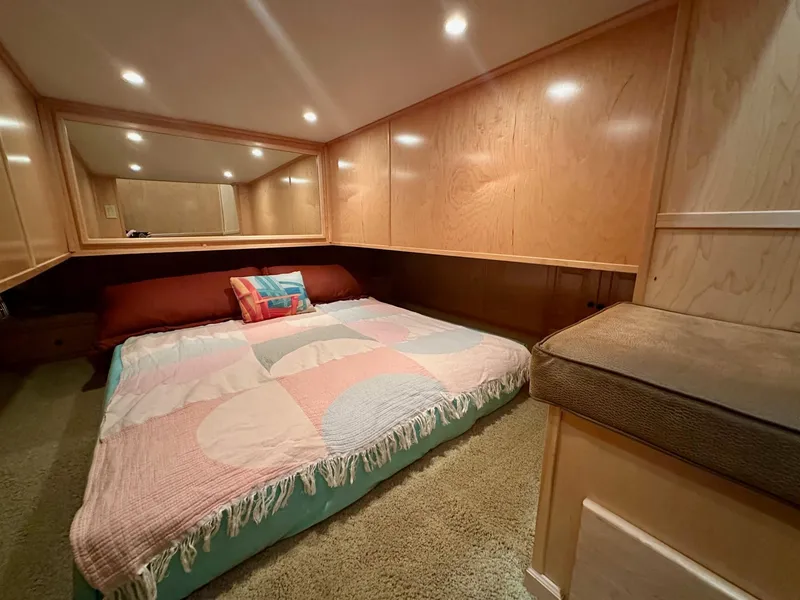 Slide: The Image of Cozy bedroom in 2006 Stardust Cruisers 16x78 houseboat with wood paneling and colorful bedding. - 8