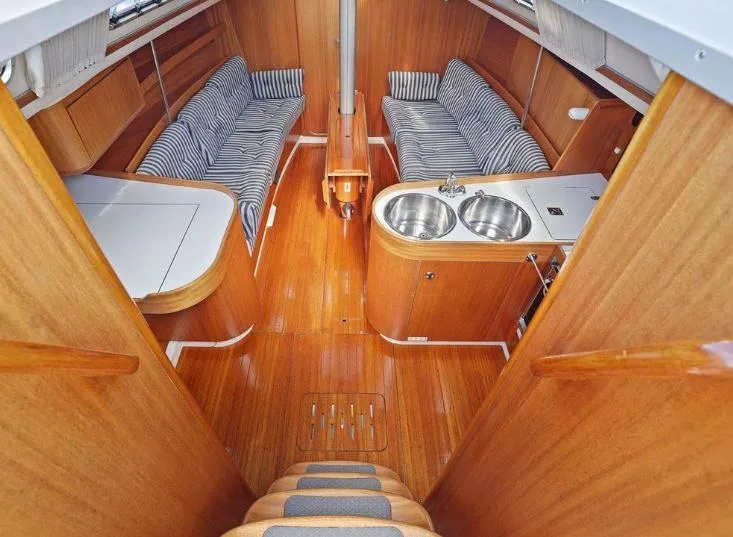 Slide: The Image of Interior of 2000 X-Yachts X-362 Sport, featuring wood finish and striped seating. - 11