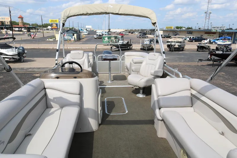 Slide: The Image of 2015 Bennington 24SSRX pontoon boat with spacious seating and canopy, displayed in a marina. - 10