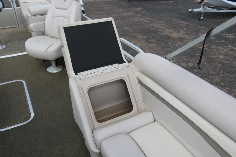 Slide: The Image of 2015 Bennington 24SSRX boat interior with beige seating and storage compartment. - 15