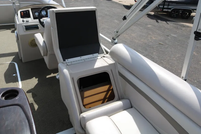 Slide: The Image of 2015 Bennington 24SSRX boat interior with open storage compartment and seating. - 18