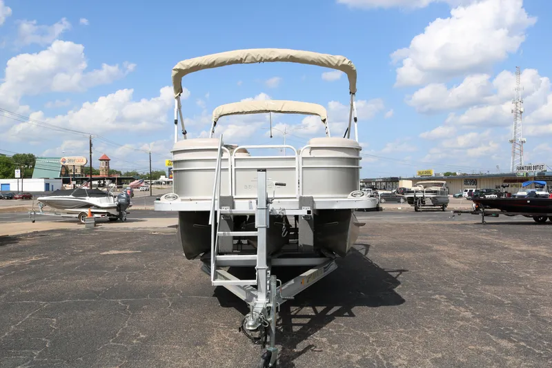 Slide: The Image of 2015 Bennington 24SSRX pontoon boat on trailer under a clear blue sky. - 2