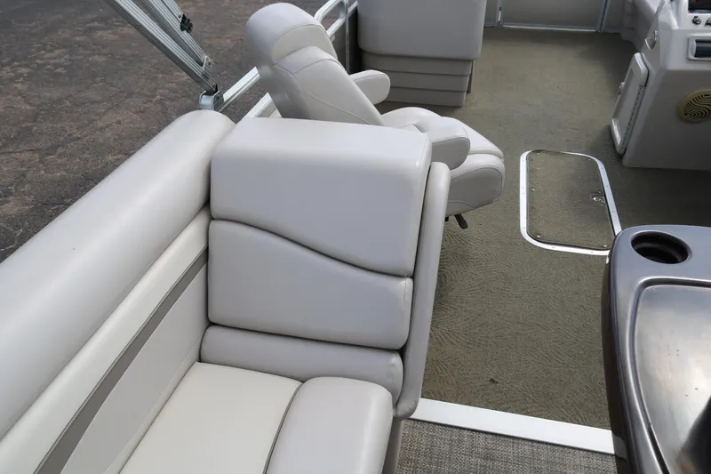 Slide: The Image of 2015 Bennington 24SSRX boat interior with plush seating and carpeted flooring. - 21