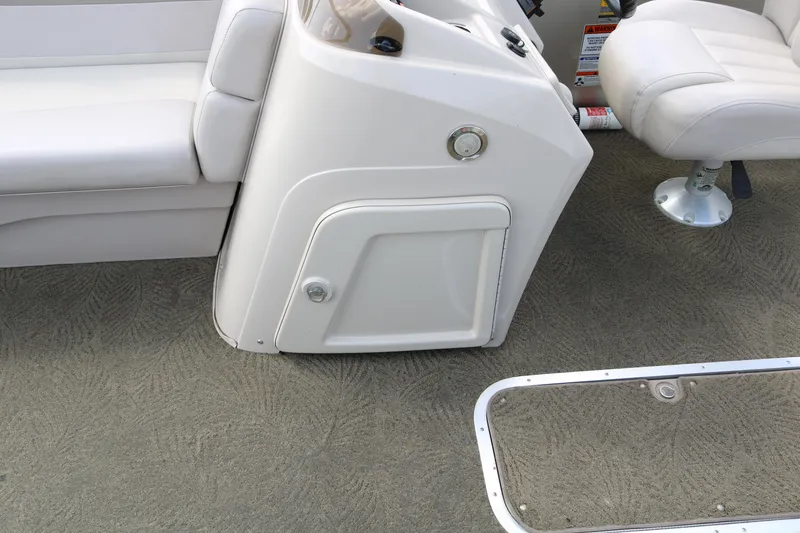 Slide: The Image of 2015 Bennington 24SSRX boat interior with white seating and control panel. - 22