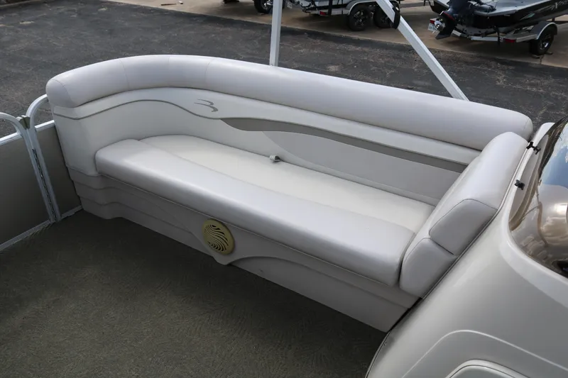 Slide: The Image of 2015 Bennington 24SSRX boat interior with white cushioned seating and speaker. - 24