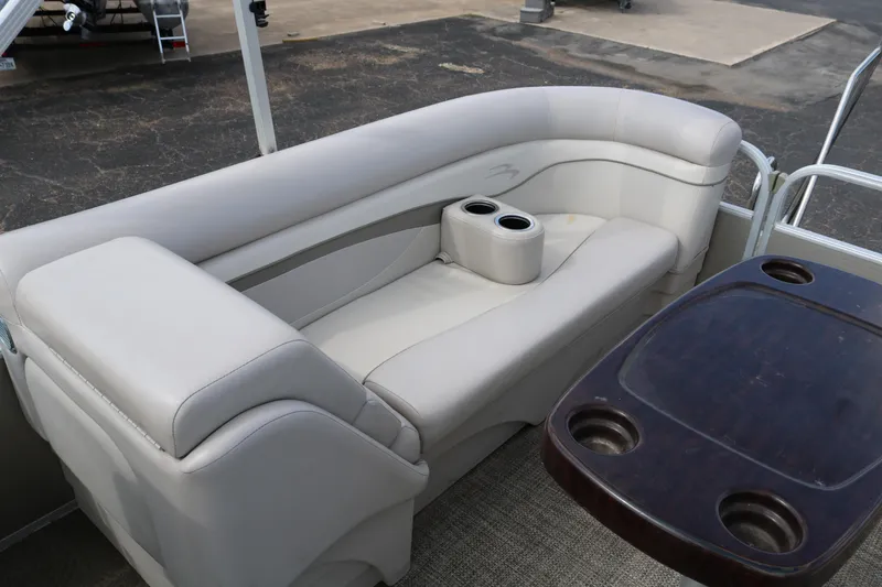 Slide: The Image of 2015 Bennington 24SSRX pontoon boat interior with beige seating and cupholders. - 27