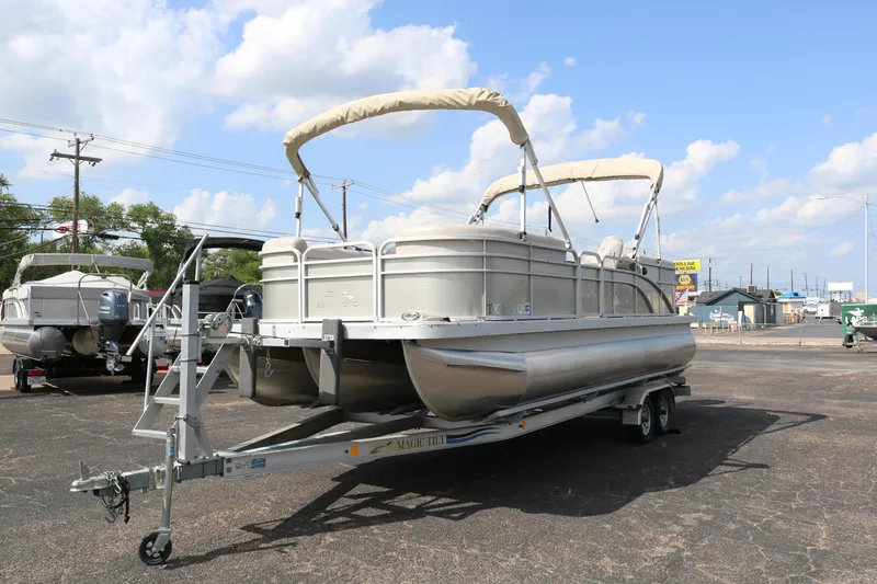 Slide: The Image of 2015 Bennington 24SSRX pontoon boat on trailer under blue sky. - 3