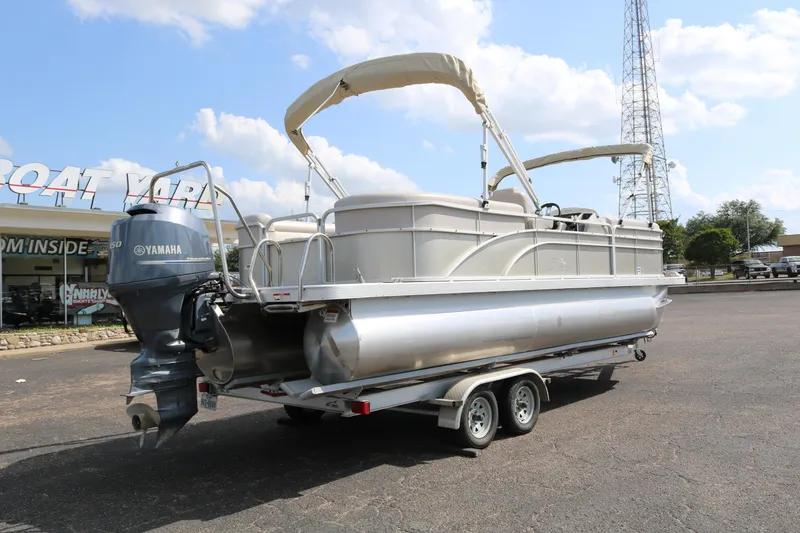 Slide: The Image of 2015 Bennington 24SSRX pontoon boat on trailer with Yamaha outboard motor, parked outdoors. - 7