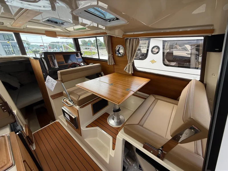 Slide: The Image of 2025 Ranger Tugs R-27 interior with wood accents and seating area. - 10