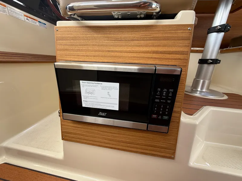 Slide: The Image of Microwave in 2025 Ranger Tugs R-27 boat interior, featuring wood paneling and modern design. - 21