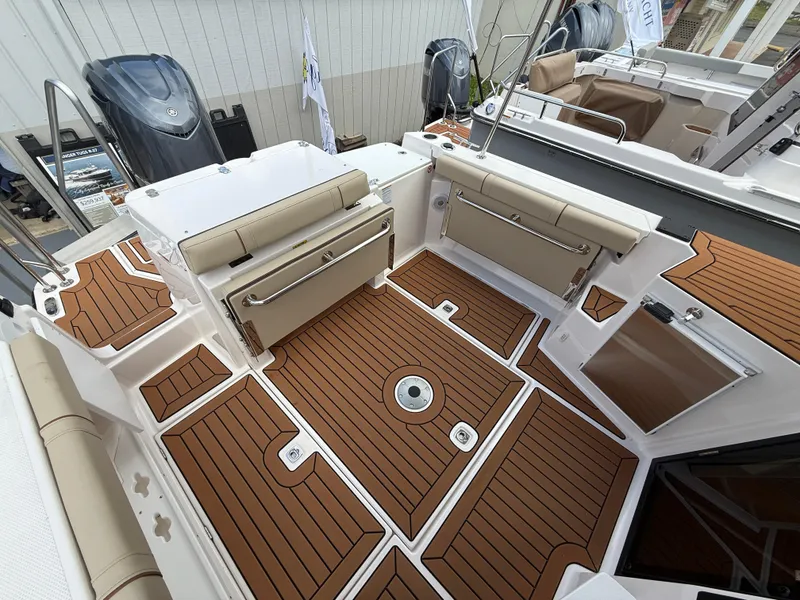 Slide: The Image of 2025 Ranger Tugs R-27 boat interior with teak flooring and foldable seating. - 6