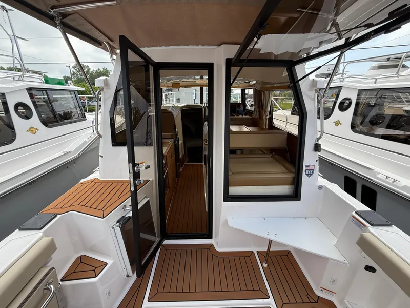 Slide: The Image of 2025 Ranger Tugs R-27 boat interior with teak flooring and open cabin view. - 9