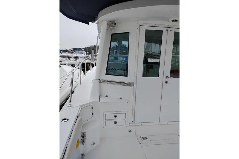 Slide: The Image of 2009 Albin 32 Tournament Express boat docked, featuring sleek white exterior and cabin entrance. - 10