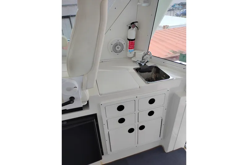 Slide: The Image of 2009 Albin 32 Tournament Express interior with sink, storage, and fire extinguisher. - 15