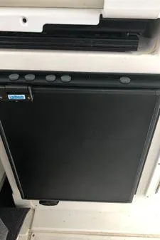 Slide: The Image of 2009 Albin 32 TE interior with a compact black refrigerator. - 16