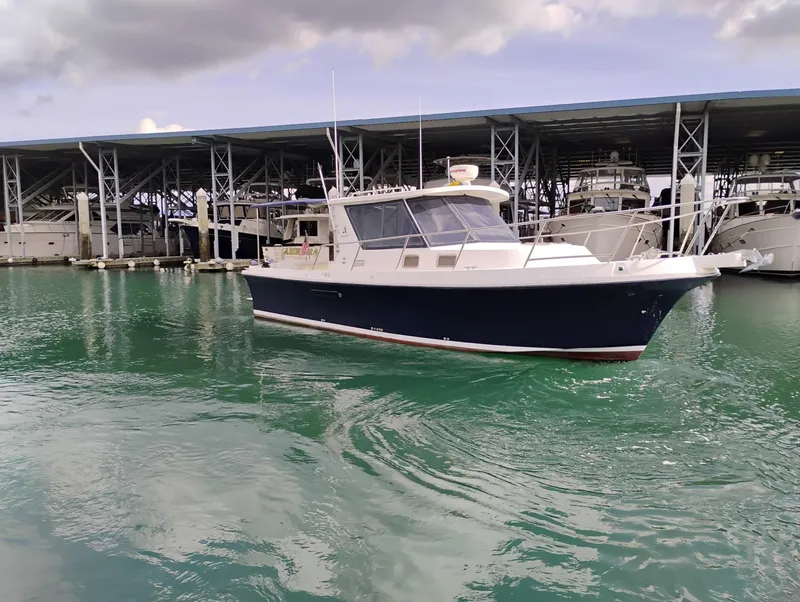 Slide: The Image of 2009 Albin 32 TE boat docked in marina with covered slips and calm water. - 2