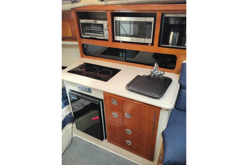 Slide: The Image of Compact kitchen area in a 2009 Albin 32 Tournament Express boat with stove, microwave, and sink. - 40