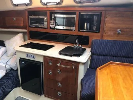 Slide: The Image of Interior of 2009 Albin 32 TE boat with kitchenette, featuring stove, microwave, and seating area. - 41