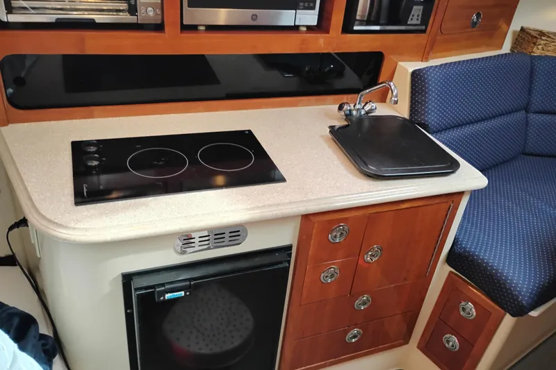 Slide: The Image of Compact kitchen area in a 2009 Albin 32 Tournament Express boat with stove and sink. - 42