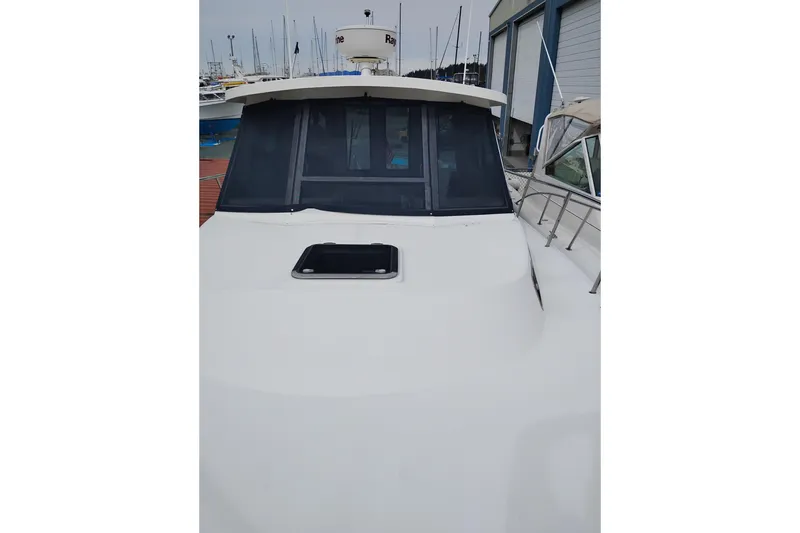 Slide: The Image of 2009 Albin 32 Tournament Express boat docked, featuring a sleek white exterior and cabin windows. - 62