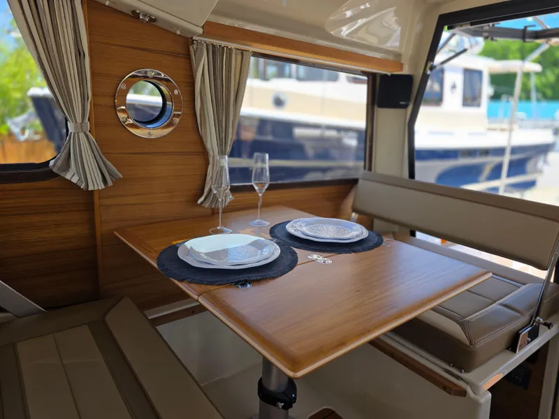 Slide: The Image of Interior of 2025 Ranger Tugs R-27, featuring a cozy dining area with elegant table settings. - 4