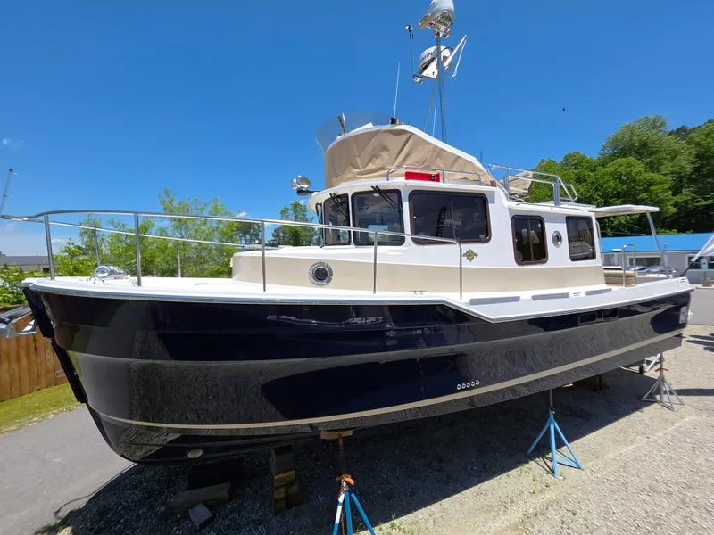 The Image of 2025 Ranger Tugs R-31 CB boat on stands, blue hull, sunny day. - 1