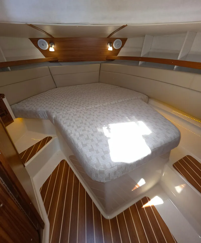 Slide: The Image of 2025 Ranger Tugs R-31 CB cabin interior with cozy bed and wooden accents. - 10