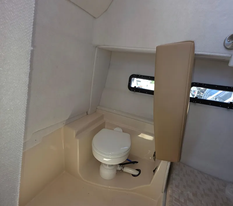 Slide: The Image of 2025 Ranger Tugs R-31 CB interior bathroom with compact toilet and window. - 12